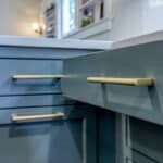 open green cabinet drawers with gold hardware