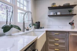 kitchen with floating shelves and white apron front farm sink