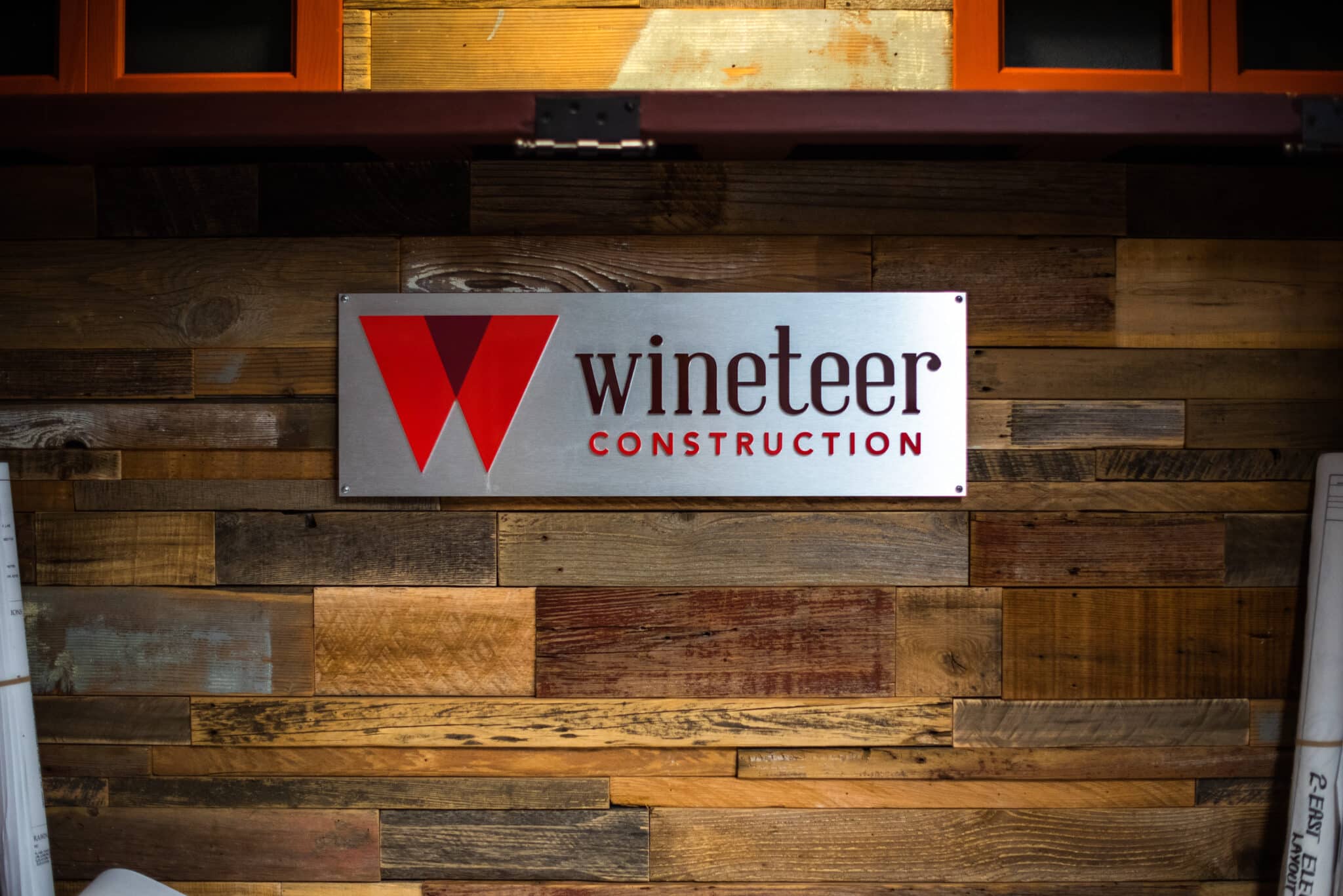 wooden background with Wineteer Construction metal sign