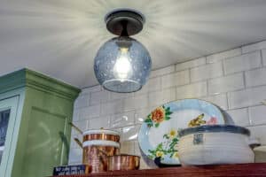 glass globule light fixture in kitchen with floating shelves