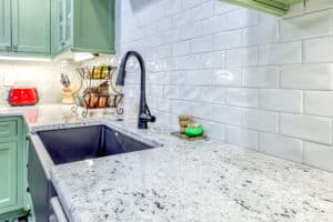 cream-white subway tile backsplash with matte black Moen faucet