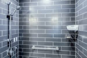 shower with navy subway tiles and chrome fixtures