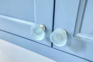 glass knobs on bathroom cabinets with blue doors