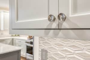 white kitchen cabinets with glass patterned backsplash