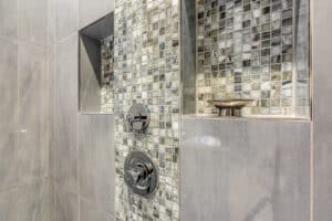 accent tile in shower caddy and panel in grays and greens
