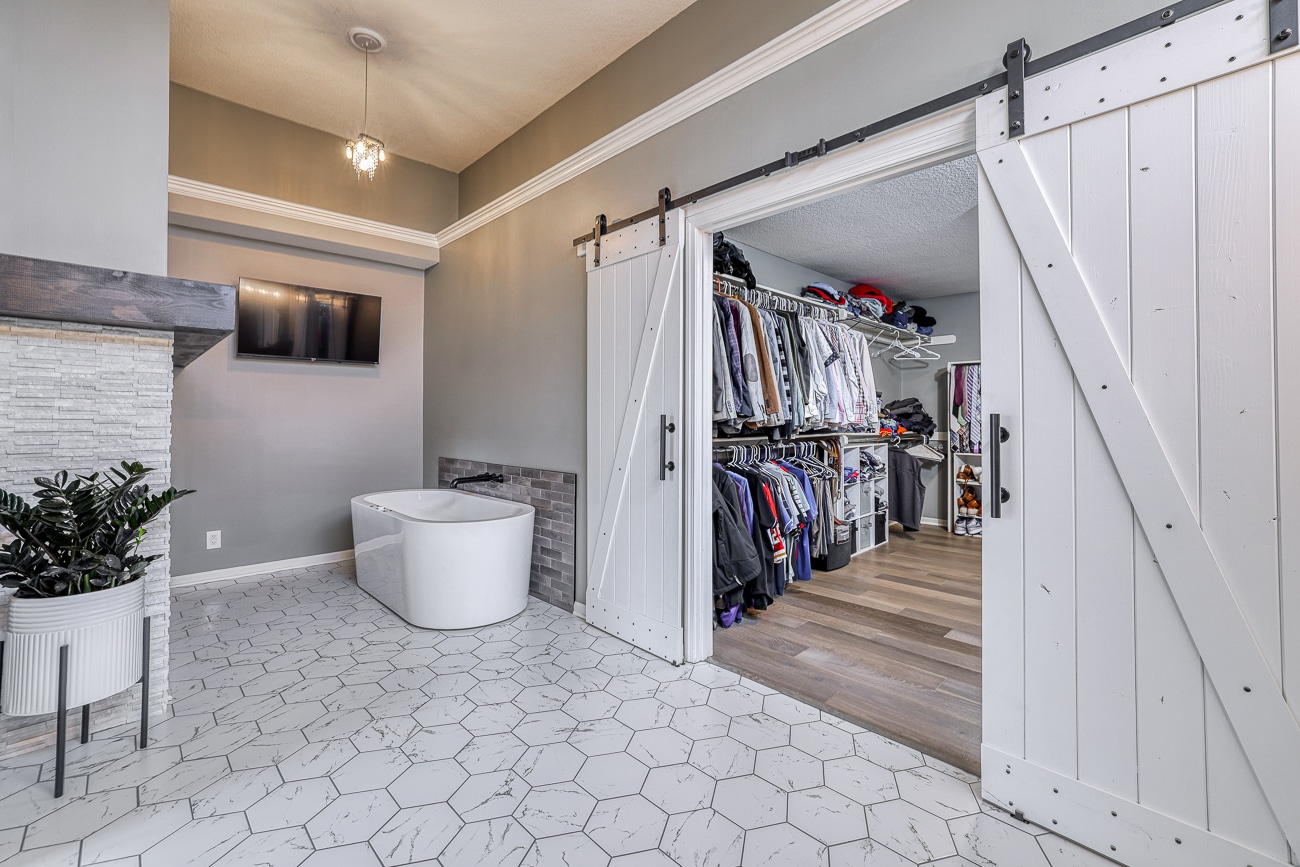 master closet and tub area with white barn doors