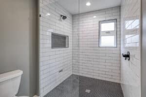 barrier free shower in white subway tile with frameless glass door
