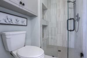 toilet and zero entry shower with a frameless glass shower door