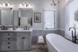 freestanding tub and updated vanity in gray with matte black fixtures in bathroom renovation project